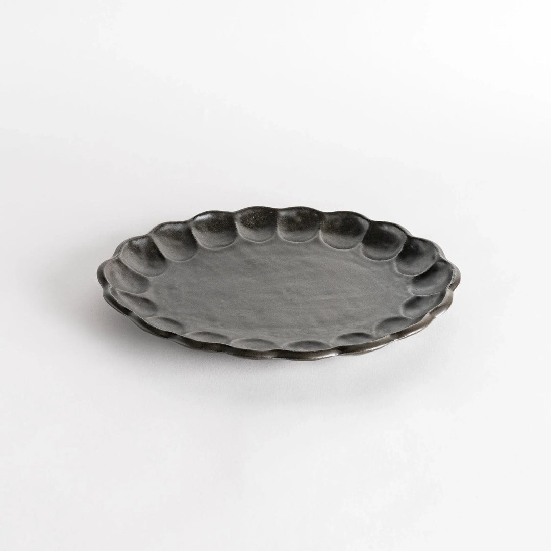 A white ceramic serving plate with a delicate, scalloped oval shape. Available in black or white.