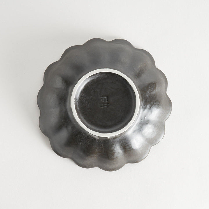 A white ceramic pasta bowl with a scalloped flower-petal design.