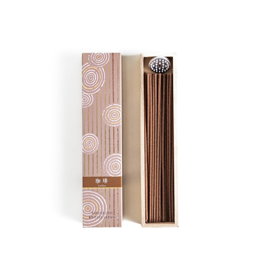 Brown incense sticks in a wooden box with beige packaging and white circular patterns evoking coffee aroma.