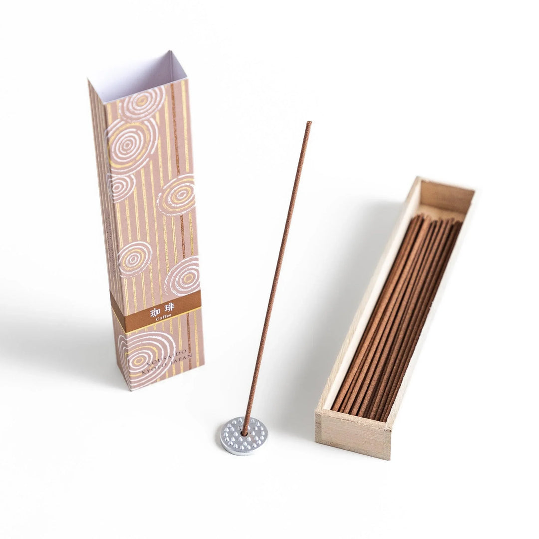 Brown incense sticks in a wooden box with beige packaging and white circular patterns evoking coffee aroma.