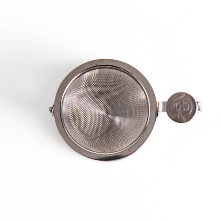 Japanese stainless steel rotating tea strainer with fine mesh and drip tray for easy loose leaf brewing.