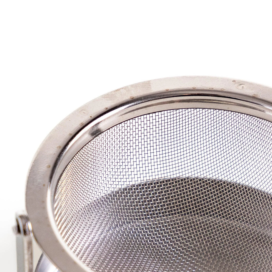 Japanese stainless steel rotating tea strainer with fine mesh and drip tray for easy loose leaf brewing.