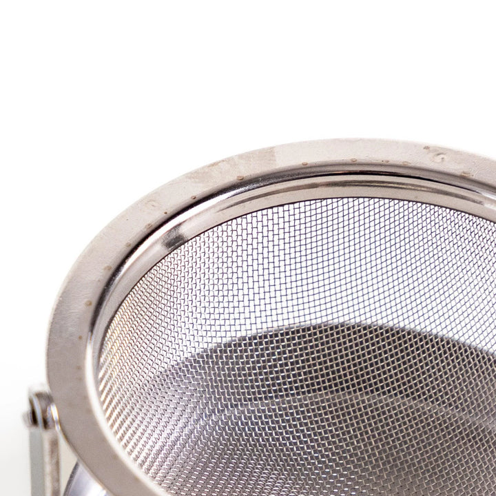 Japanese stainless steel rotating tea strainer with fine mesh and drip tray for easy loose leaf brewing.