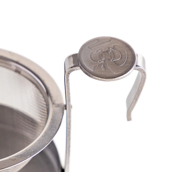 Japanese stainless steel rotating tea strainer with fine mesh and drip tray for easy loose leaf brewing.