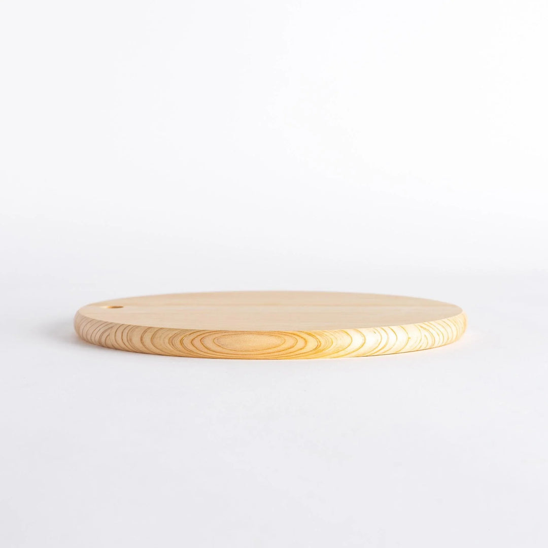 Side view of a round Hinoki cutting board showing its thickness and hole.