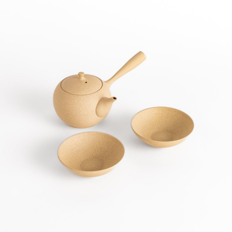 Beige tea set with round teapot and matching bowls, perfect for a serene and refined tea experience.