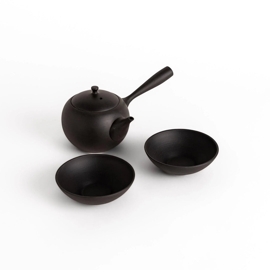 Black tea set with round teapot and matching bowls, designed for elegant and calming tea moments.