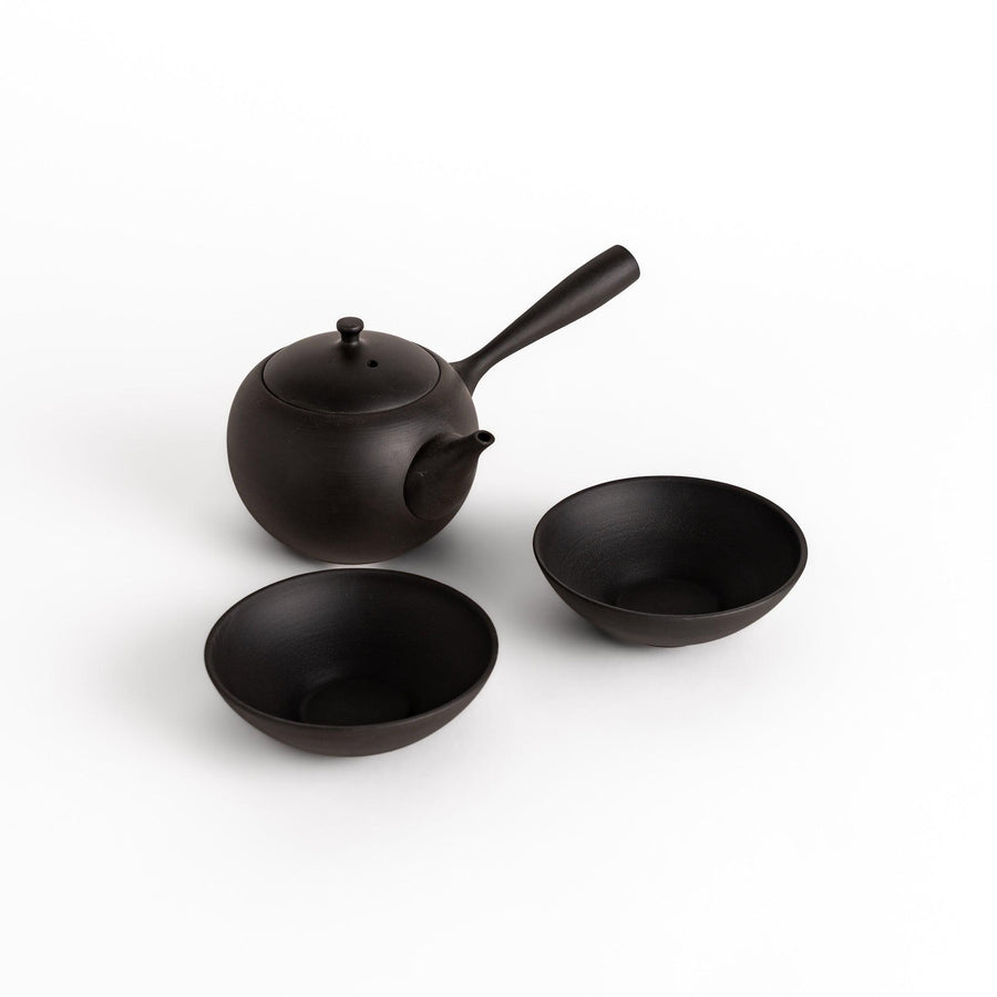 Black tea set with round teapot and matching bowls, designed for elegant and calming tea moments.