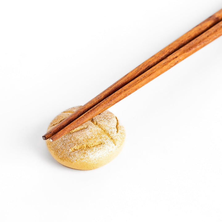 Rustic bread-shaped chopstick rest, featuring a natural, earthy design with a leaf-like scoring on top.