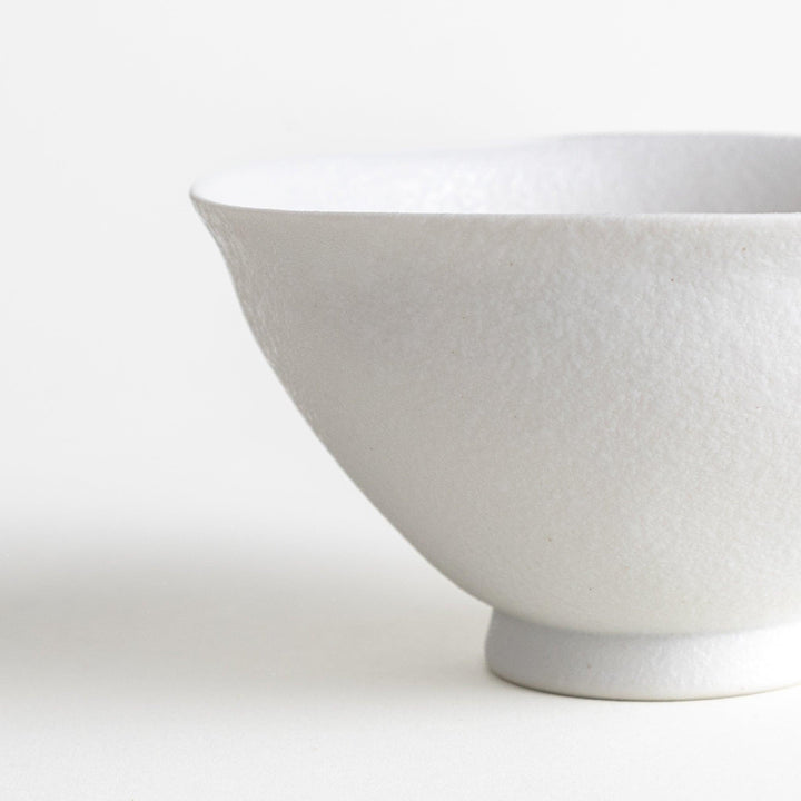 Matte ceramic rice bowls, one in black and the other in white, with a simple, elegant design.