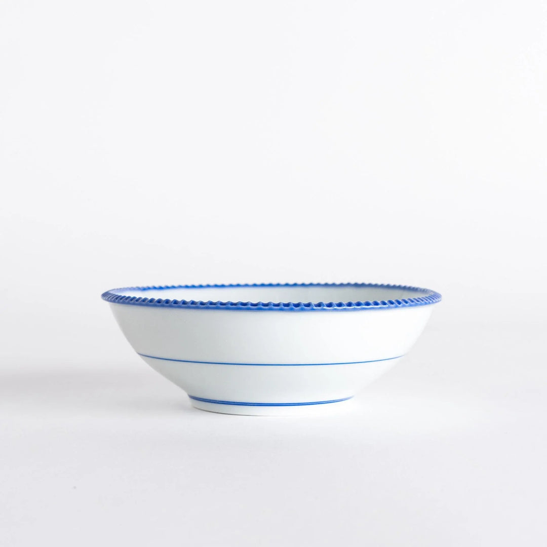 Side view of the cereal bowl displaying its smooth curves and blue scalloped detailing.