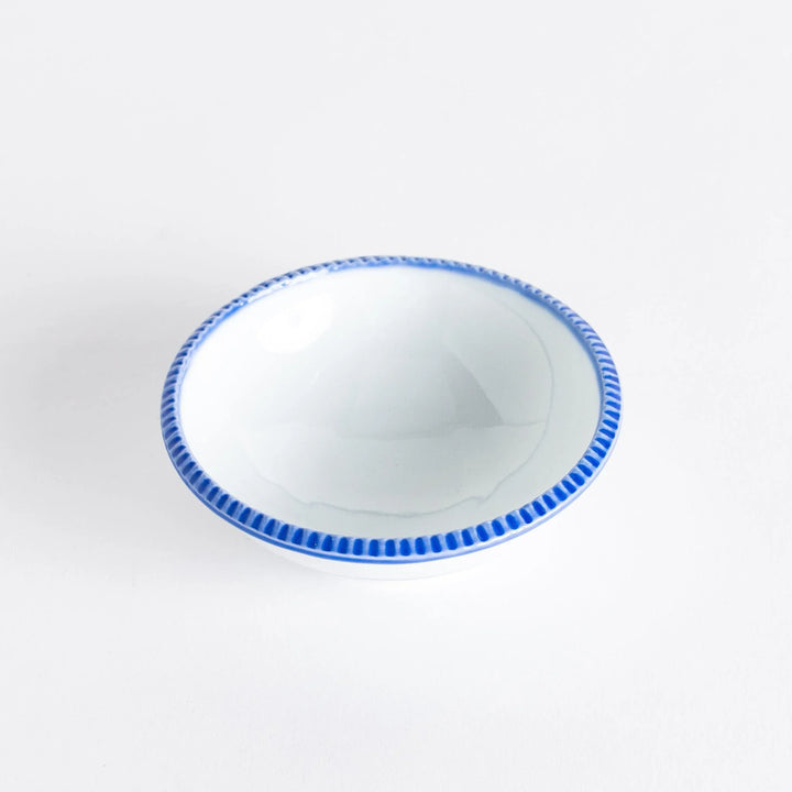 A round white dessert bowl with a rustic scallop-edged border. The border comes in blue, brown, and olive.