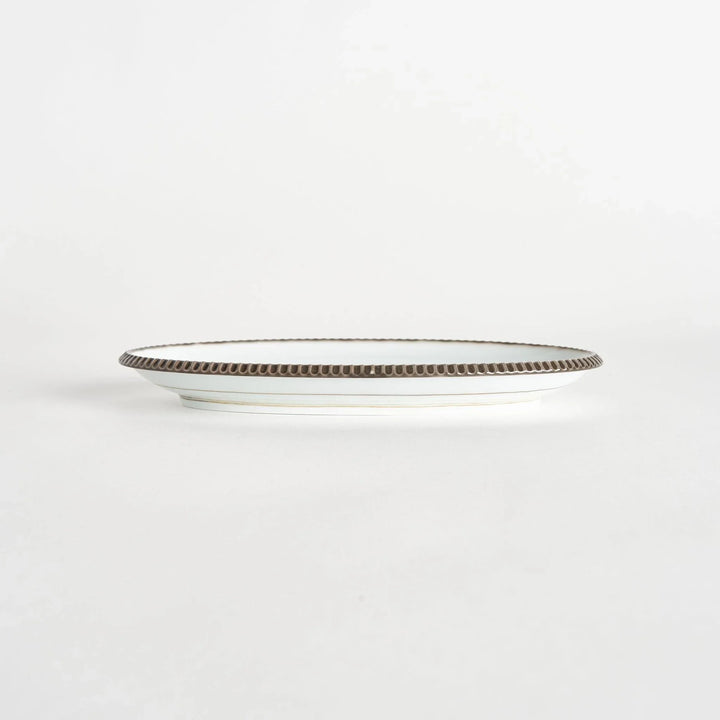 Side view of an oval salad plate with a subtle olive-colored scalloped edge.