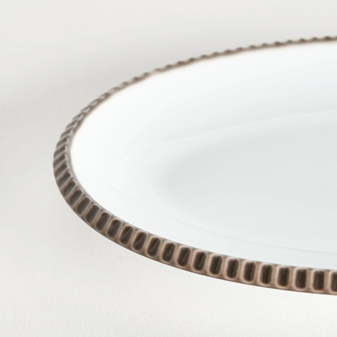 Close-up of the olive-colored scalloped edge of the oval salad plate, highlighting its natural design.