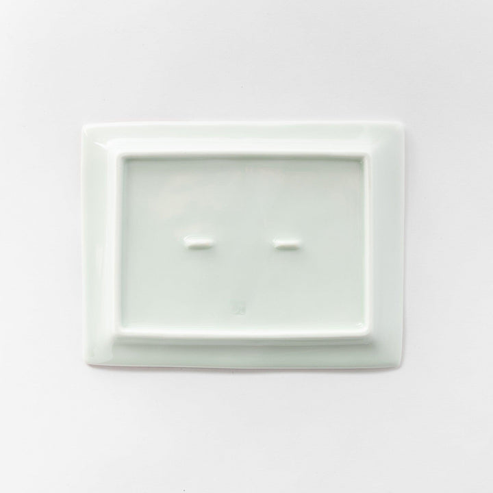 Underneath view of the dessert plate, showing the smooth, white porcelain base.