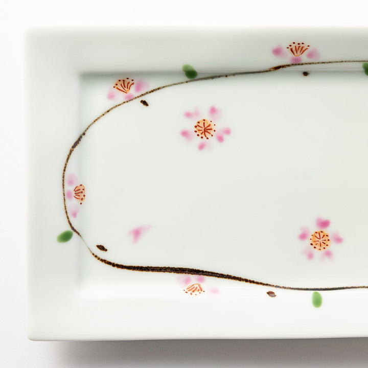 Close-up of the cherry blossom pattern, showing intricate pink flowers and green accents on the plate.