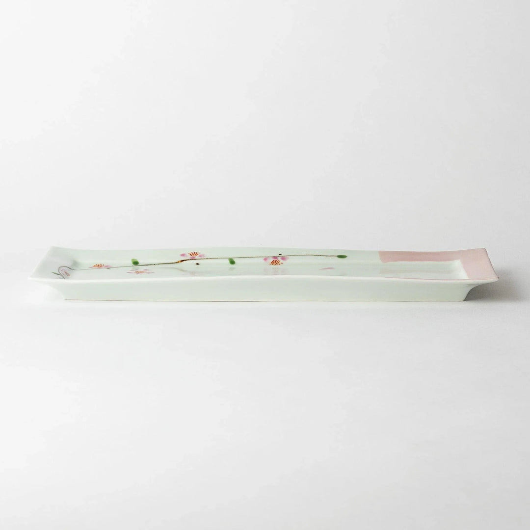 Side view of a rectangular plate featuring cherry blossoms, emphasizing its slim profile and elegant design.