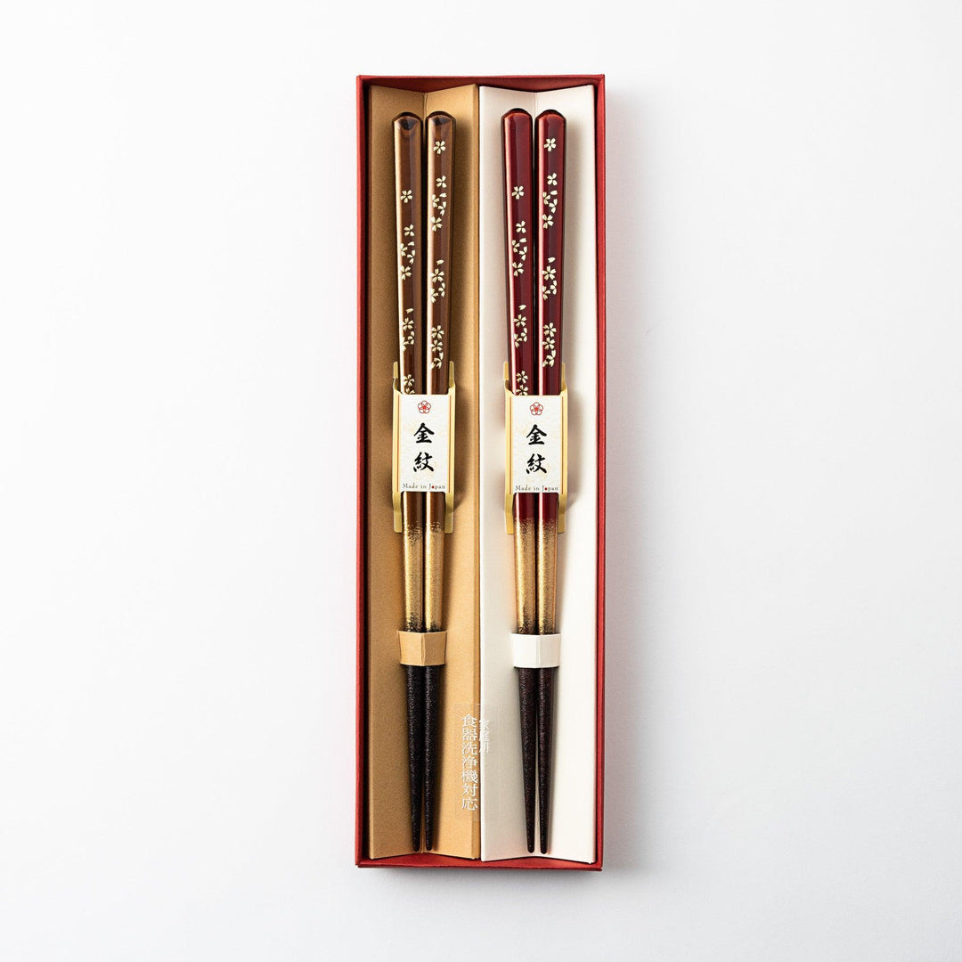 Elegant red and brown lacquered chopsticks adorned with delicate gold cherry blossom motifs, featuring a gradient of gold for added sophistication.