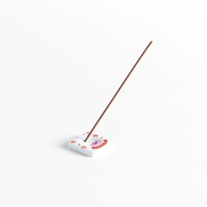 Square ceramic incense holder with sakura rabbit design in pink and red crafted to hold incense with elegance.