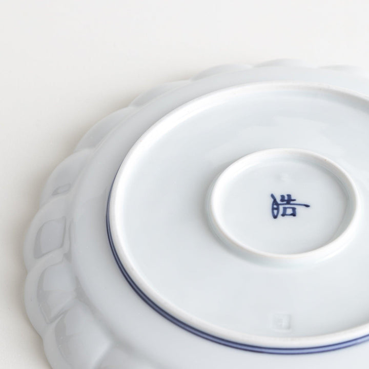 White salad plate with scalloped edges, outlined in a thin blue or red line.