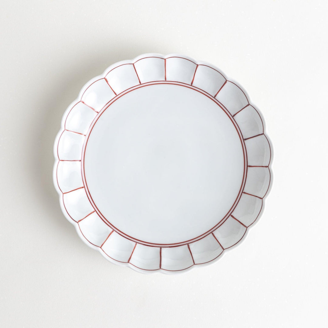 White salad plate with scalloped edges, outlined in a thin blue or red line.