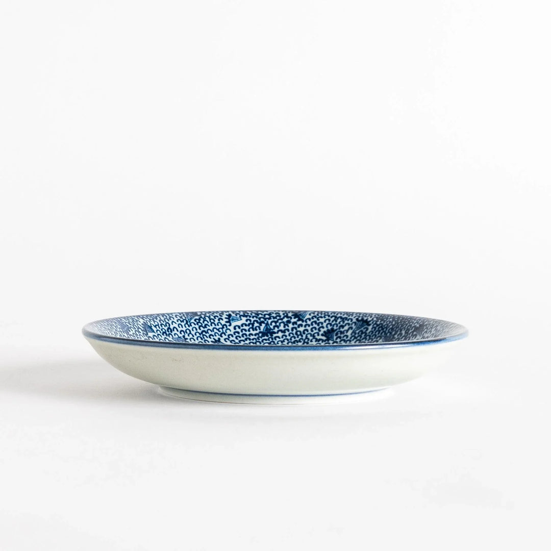 A shallow round plate with a speckled blue pattern covering the surface.