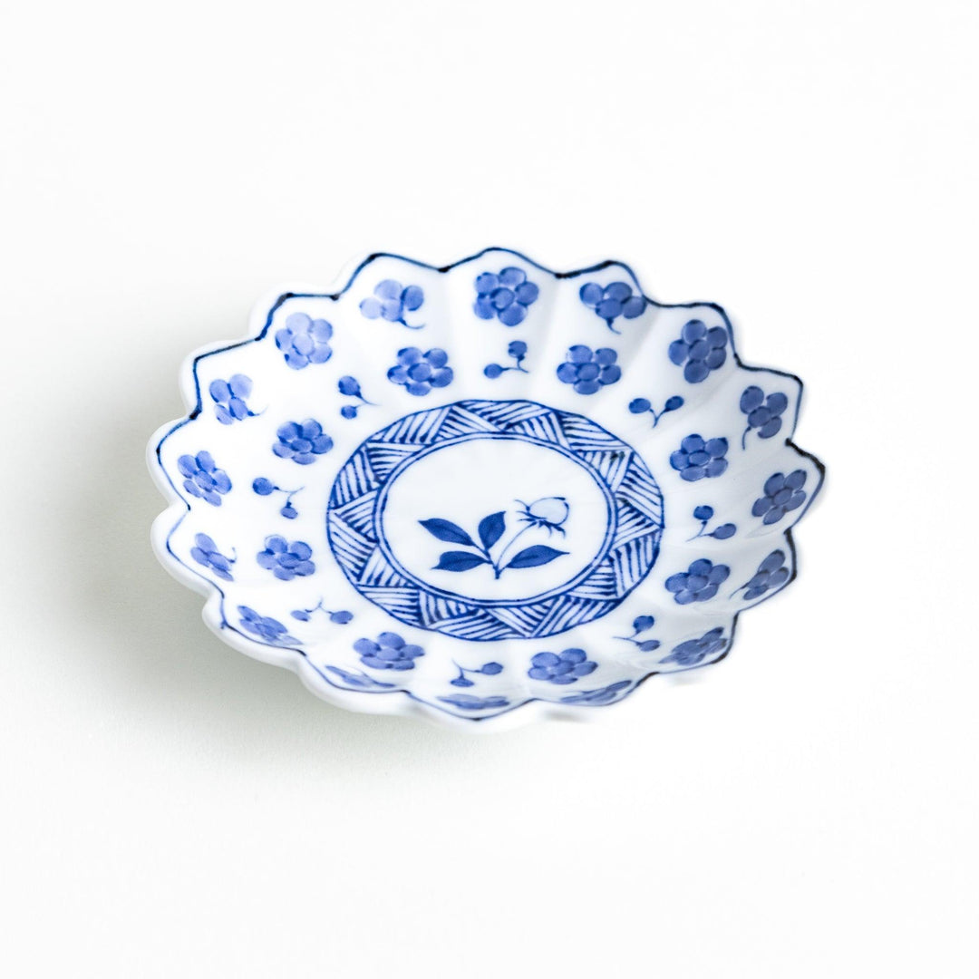 White plate with blue floral designs and a scalloped edge.
