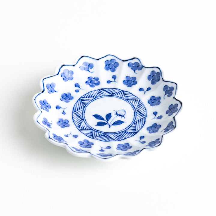 White plate with blue floral designs and a scalloped edge.
