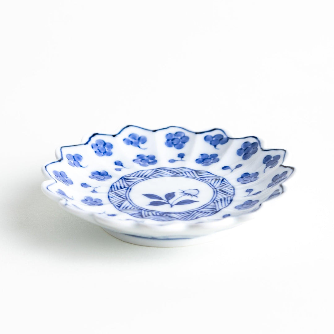 White plate with blue floral designs and a scalloped edge.
