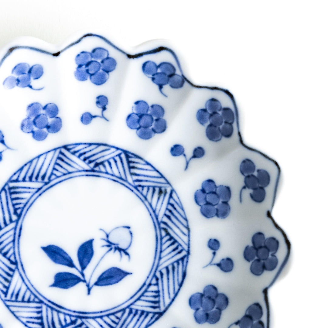 White plate with blue floral designs and a scalloped edge.
