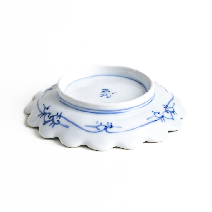 White plate with blue floral designs and a scalloped edge.
