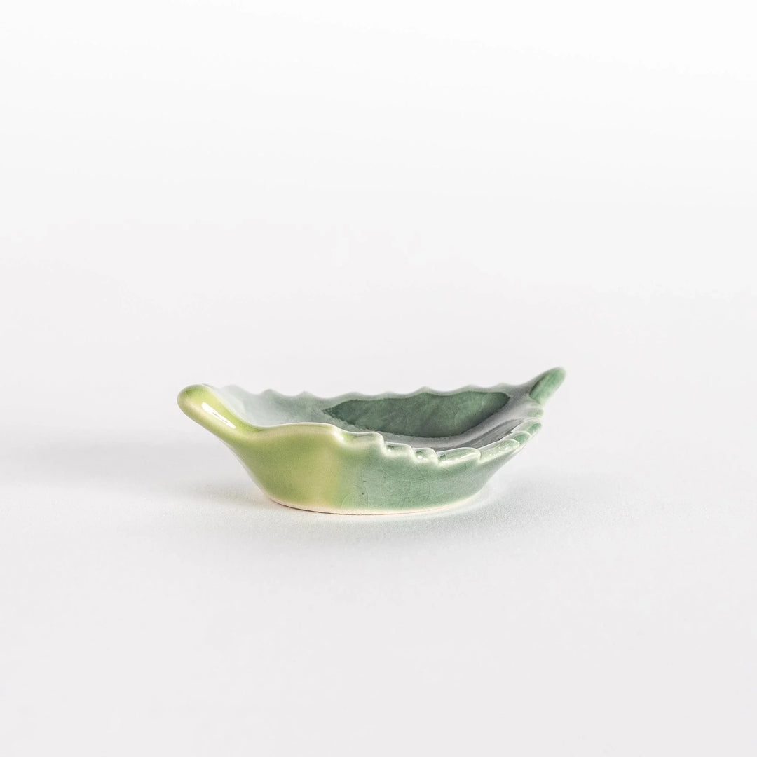 Side view of the ceramic shiso leaf chopsticks rest, highlighting its raised edges and glossy finish.