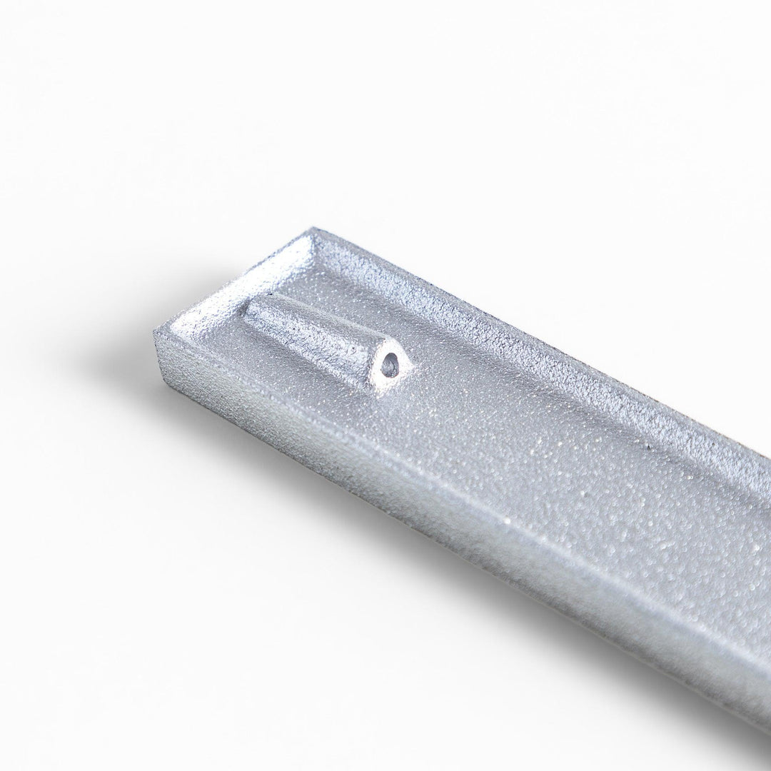 Aluminum incense holder with tray and slot design, holding incense securely and collecting falling ash.