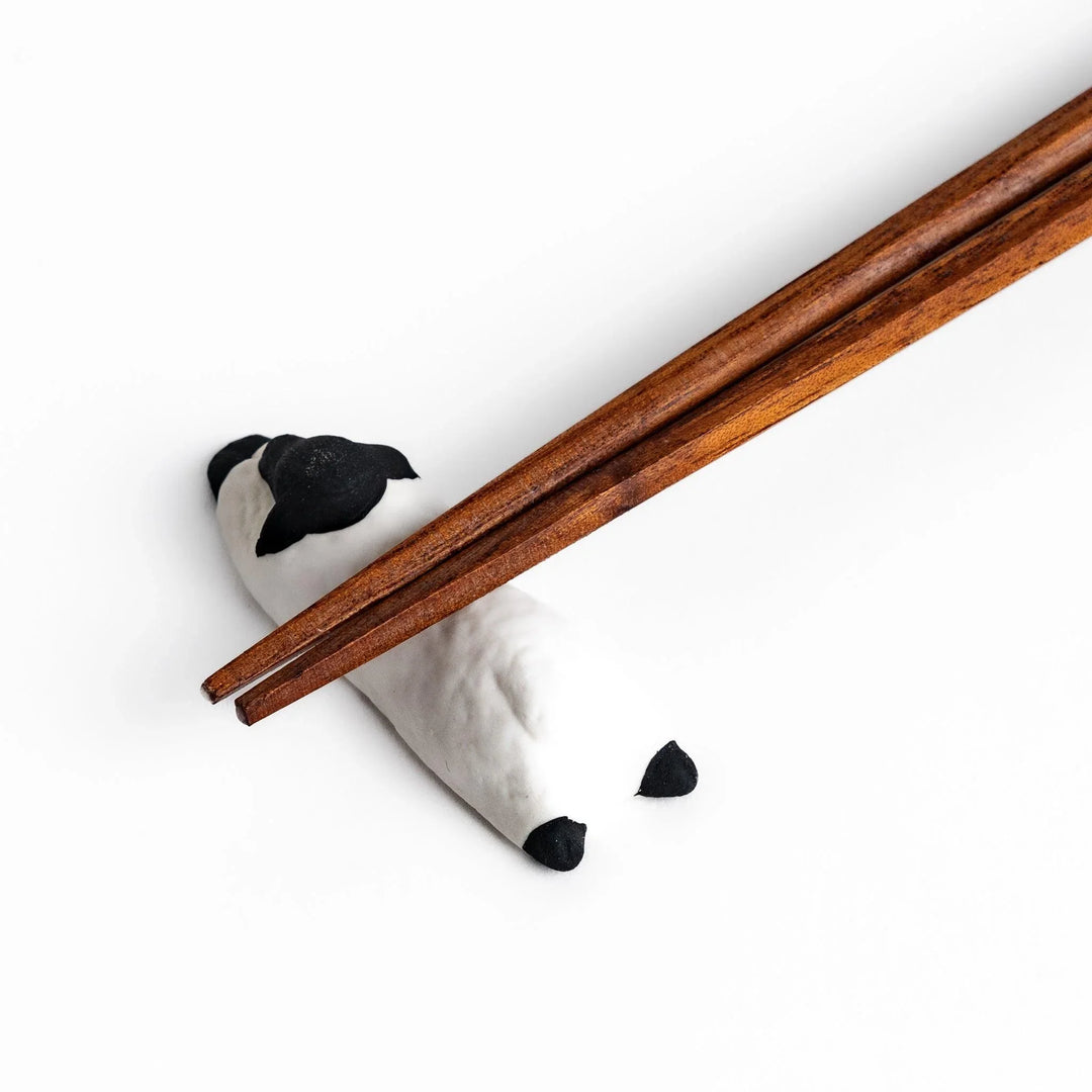 Sleeping sheep chopstick rest in black and white, crafted with a minimalist design for a playful touch.