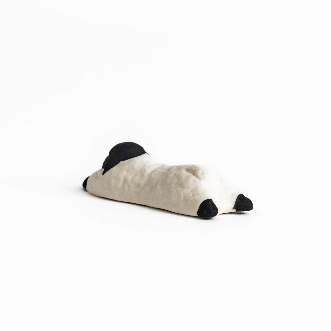 Sleeping sheep chopstick rest in black and white, crafted with a minimalist design for a playful touch.