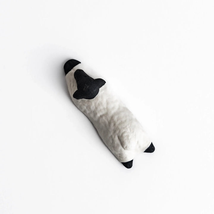 Sleeping sheep chopstick rest in black and white, crafted with a minimalist design for a playful touch.