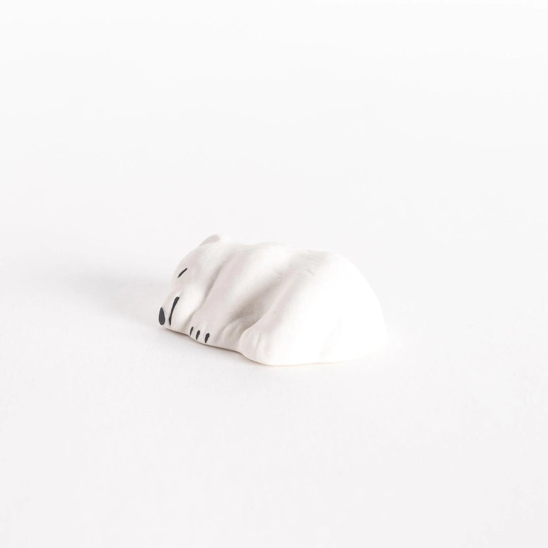 Sleepy bear ceramic chopstick rest with gentle expression adding cute and cozy charm to table setting.