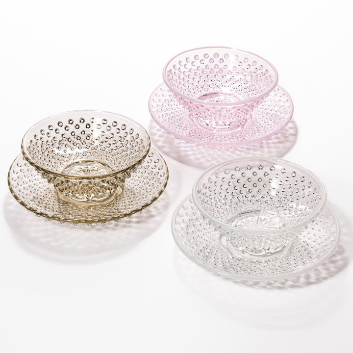 Glass dessert bowl and saucer available in pink, amber, and clear, each with raised dots and radiant base design.