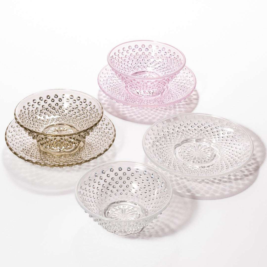 Glass dessert bowl and saucer available in pink, amber, and clear, each with raised dots and radiant base design.