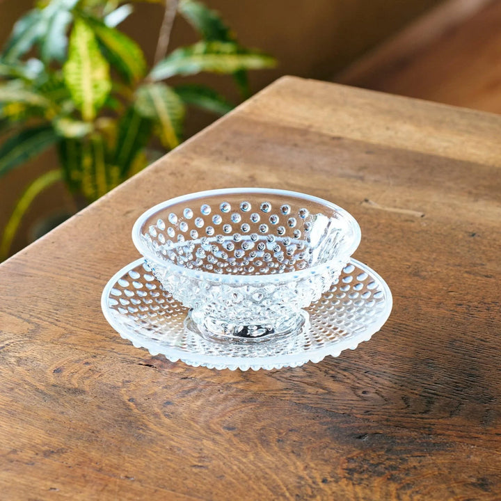 Clear glass dessert bowl and saucer with raised dots and starburst base, perfect for elegant desserts or fruit.