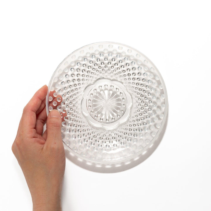 Clear glass dessert bowl and saucer with raised dots and starburst base, perfect for elegant desserts or fruit.