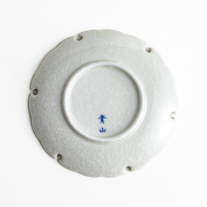 Ceramic sauce dishes with scalloped edges, available in black and white.