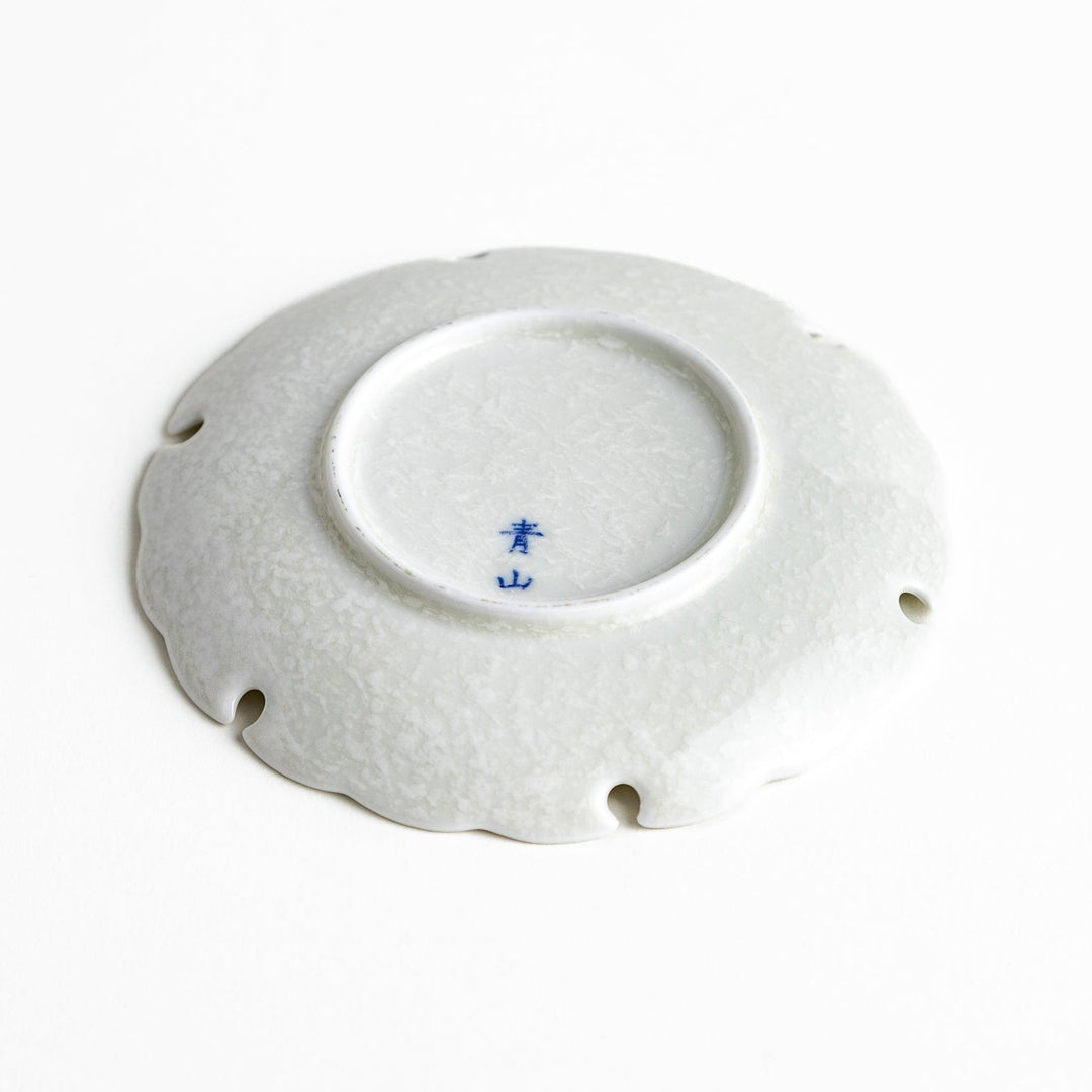 Ceramic sauce dishes with scalloped edges, available in black and white.