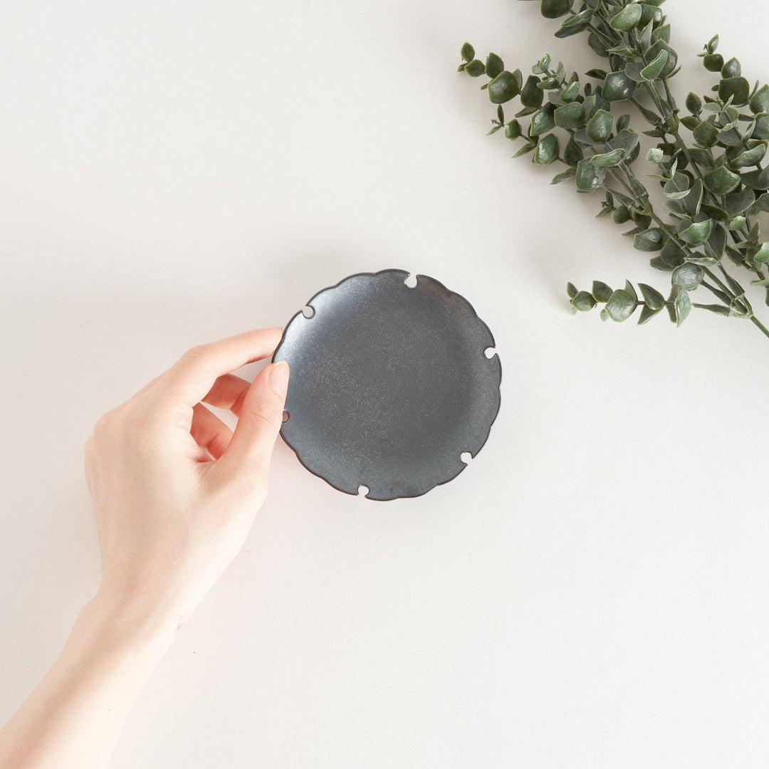 Ceramic sauce dishes with scalloped edges, available in black and white.