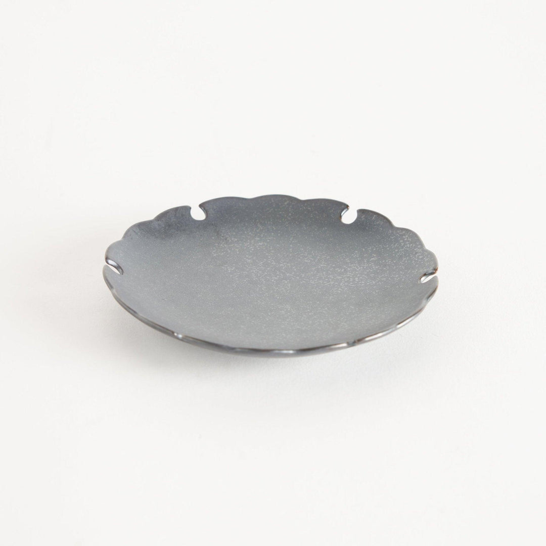 Ceramic sauce dishes with scalloped edges, available in black and white.