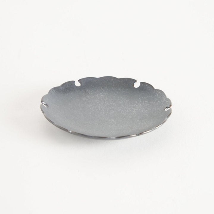 Ceramic sauce dishes with scalloped edges, available in black and white.