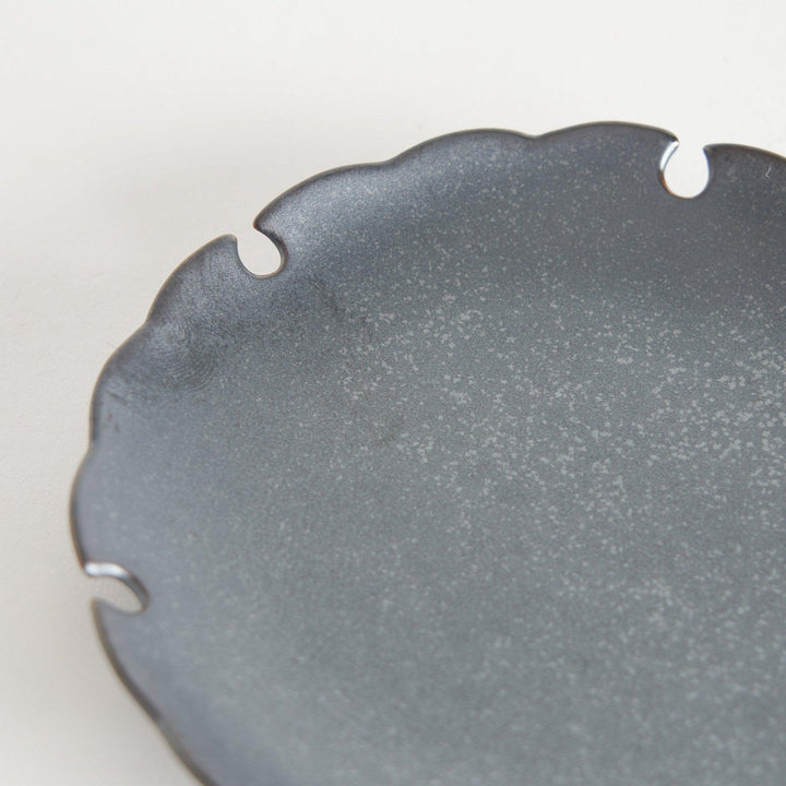 Ceramic sauce dishes with scalloped edges, available in black and white.