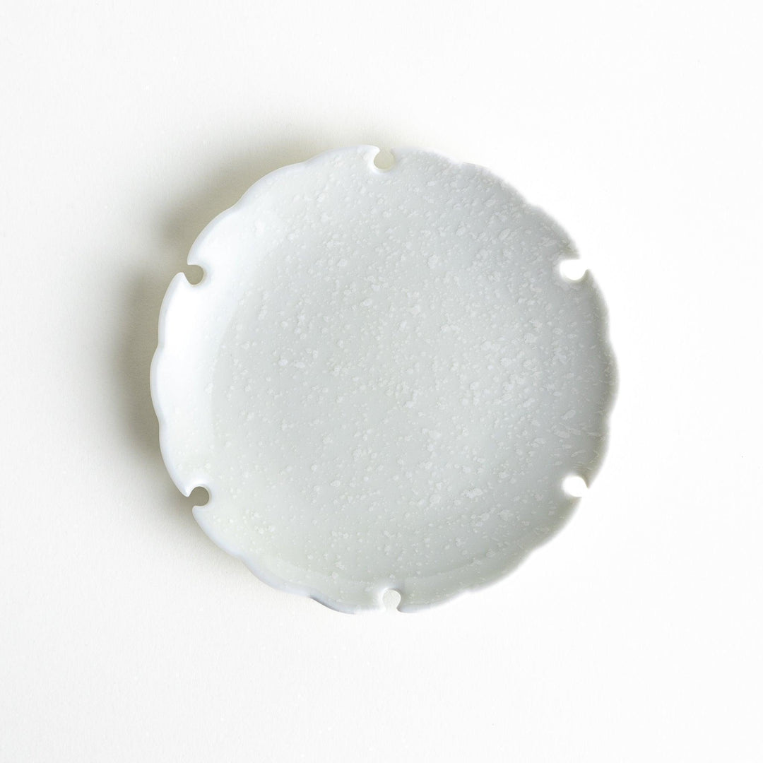 Ceramic sauce dishes with scalloped edges, available in black and white.