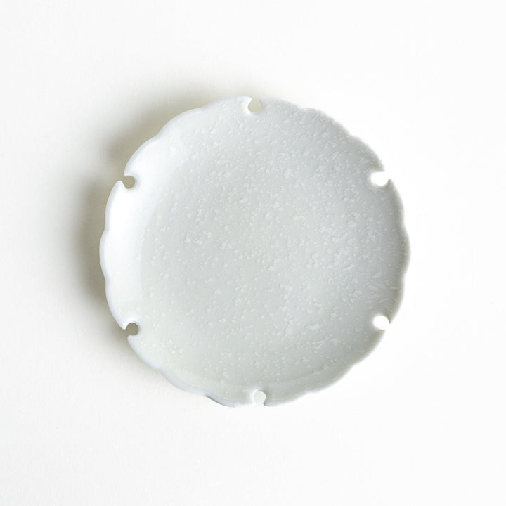 Ceramic sauce dishes with scalloped edges, available in black and white.