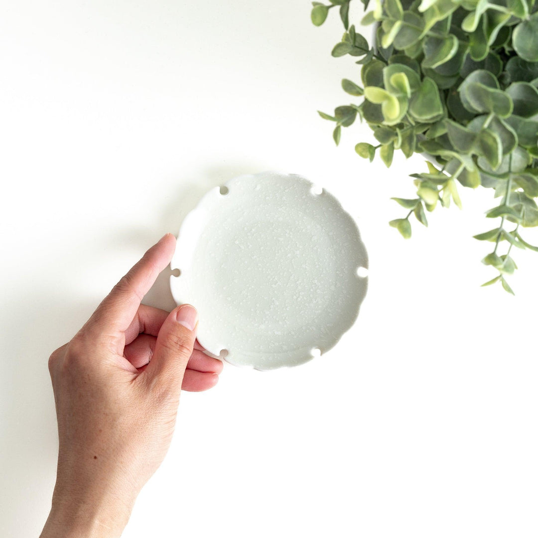 Ceramic sauce dishes with scalloped edges, available in black and white.